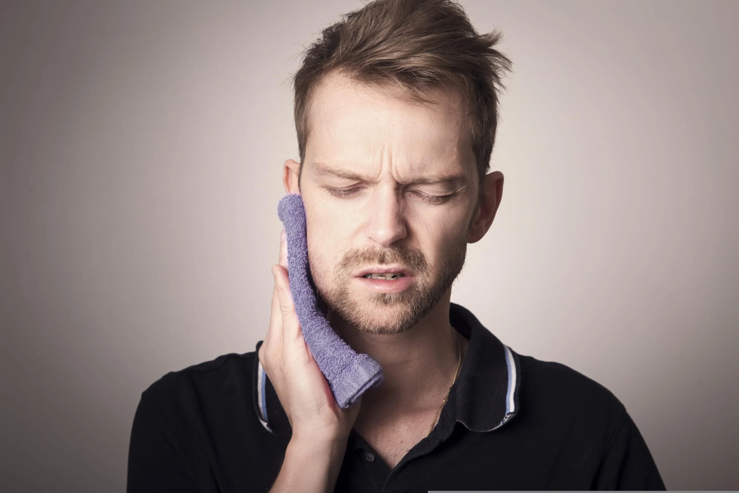 Man putting cold press to relieve pain from wisdom teeth.
